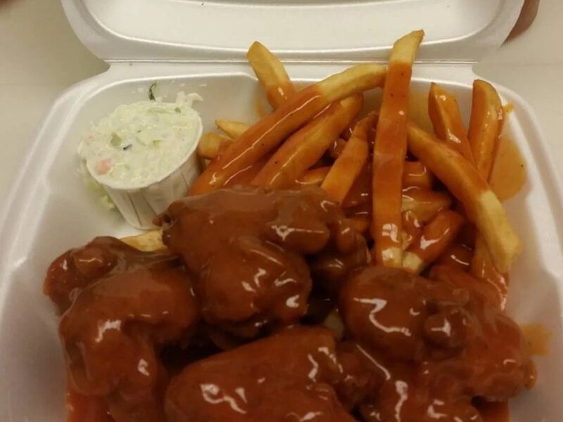 Wing dinner with saucy wings, fries and coleslaw