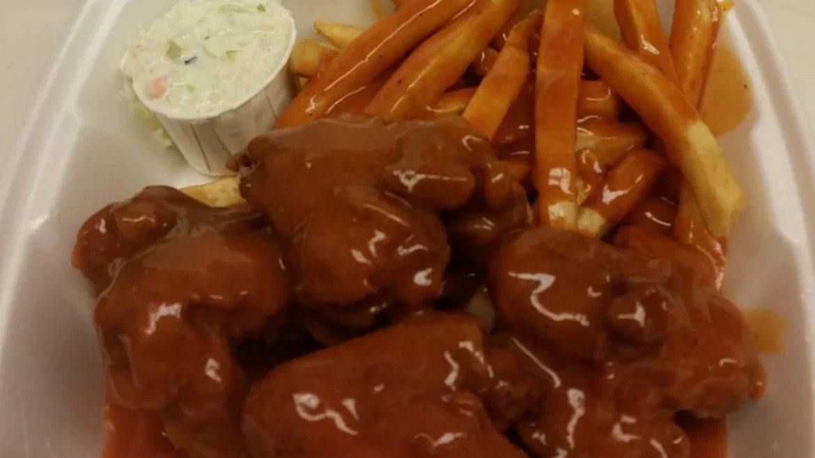 Kim's Wings sauced wings with fries and coleslaw in a to-go box